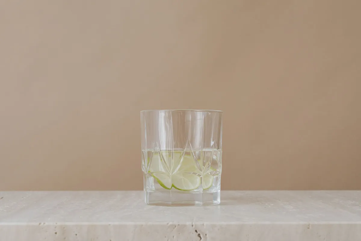 A clear glass of water on a light surface near a window with soft natural light