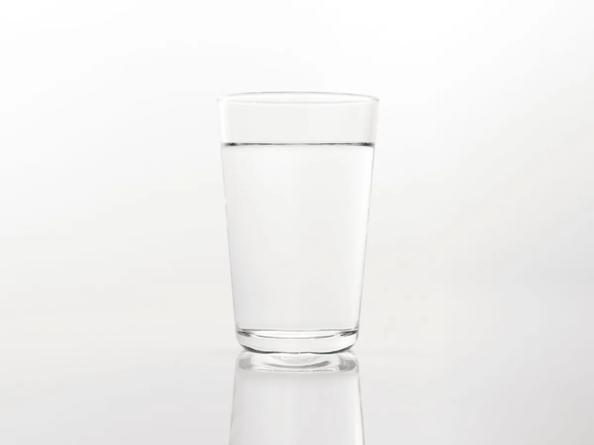 A clear glass of drinking water on a bright surface in soft natural light