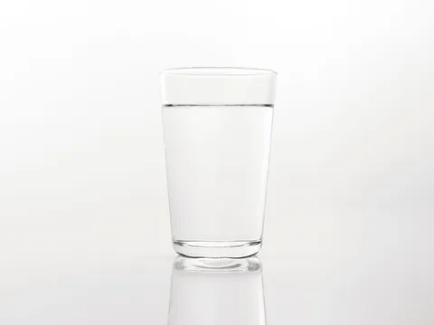 A clear glass of drinking water on a bright surface in soft natural light