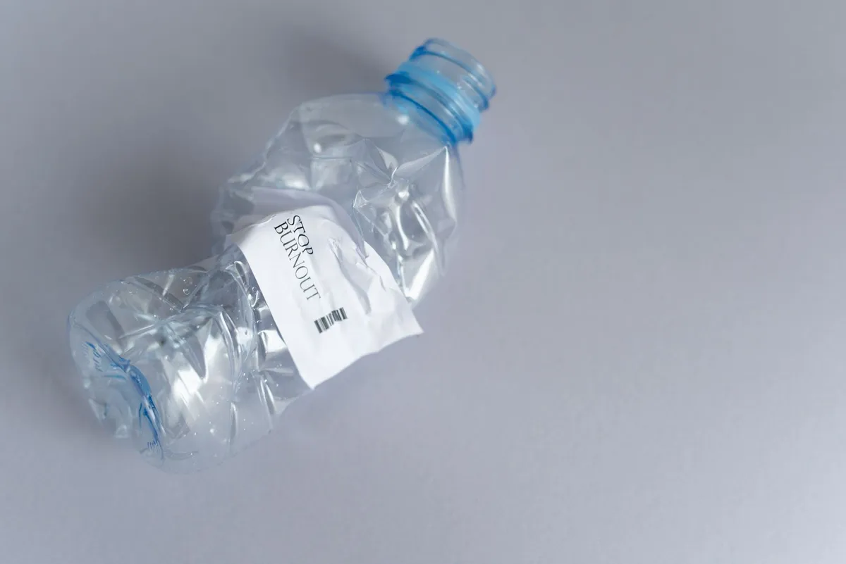 A single-use plastic water bottle on a plain surface in bright natural light