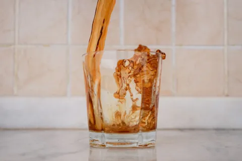 A glass of clear drinking water on a light kitchen counter in natural daylight