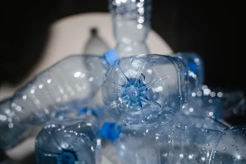 A single-use plastic water bottle on a plain surface in soft natural light